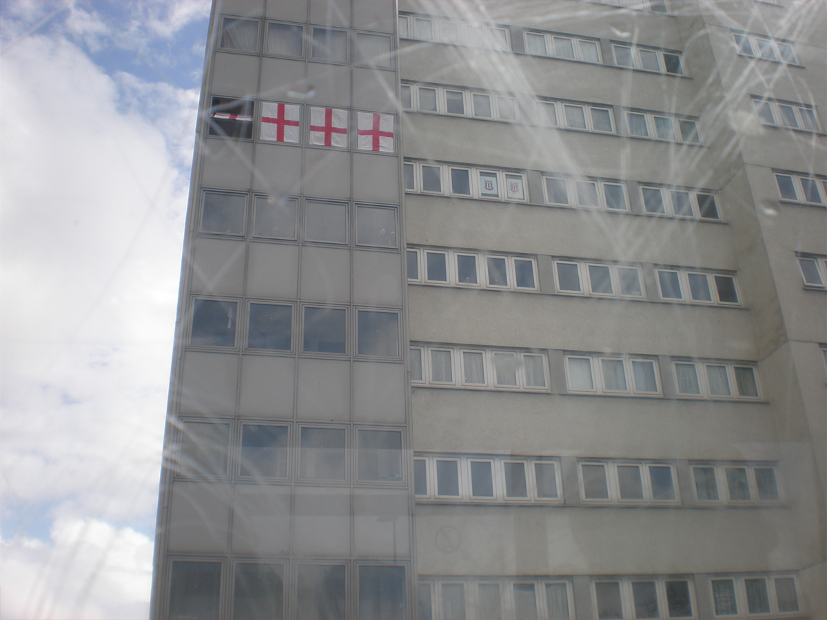 Photo of England flags in window of high rise flat