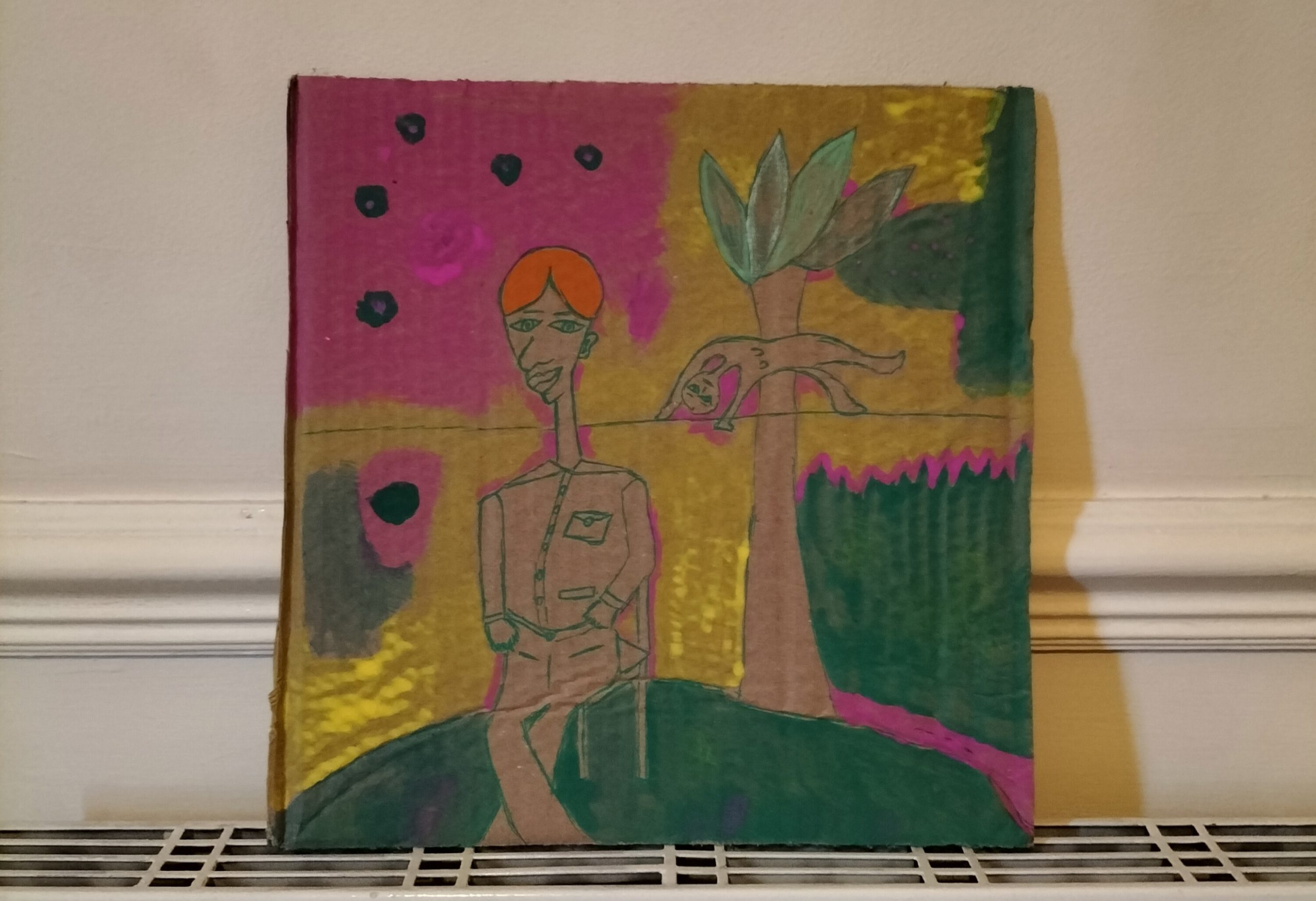 Cardboard art - Indian boy - male figure sitting down. Smaller figure in the air and behind that figure is a tree. Mixed colour background of green, pink and yellow and some dark spots. The male figure has orange hair.