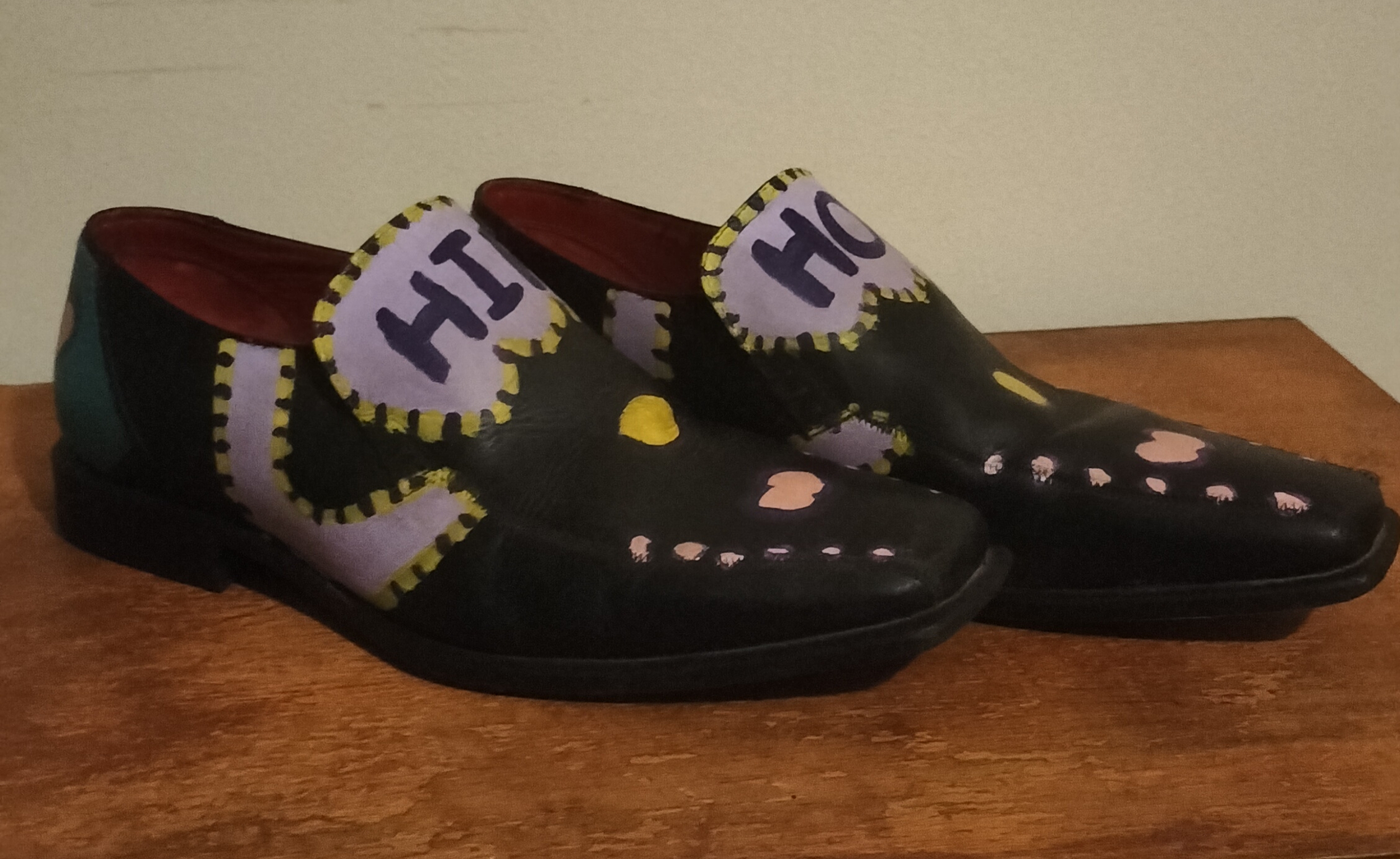 Size 8 slip on leather shoes with the words Hip Hop hand painted on them. Original design using lilac, yellow and black paint. Pink and yellow liver spots on the front. Hip on one shoe and Hop on the other on the top of the front of the shoes which is high on your foot. Turqoise painted on the heels of the shoes and pink liver spots with dark surround. One offs.