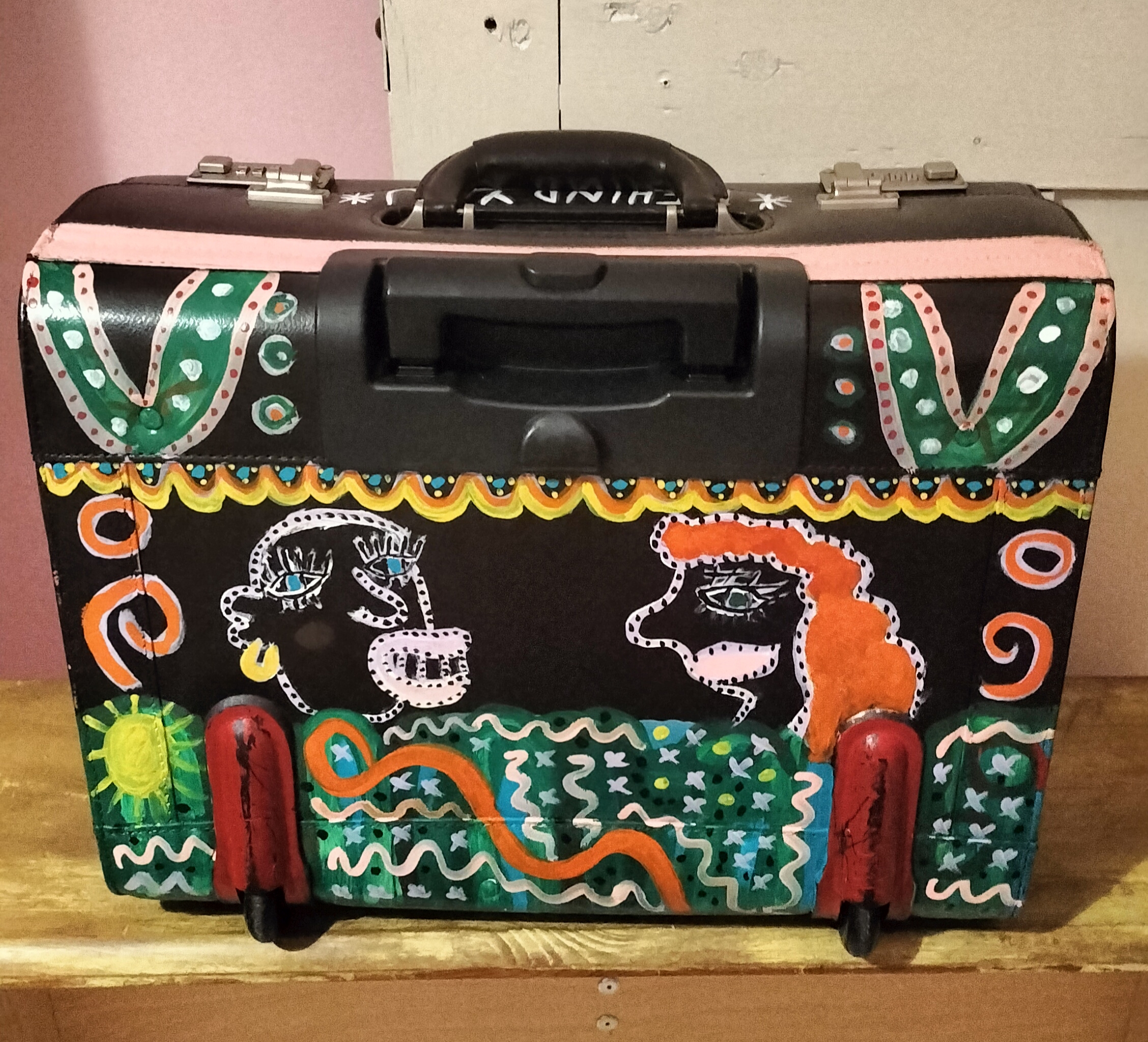 Back of hand painted pilot case with a scene referencing Punch and Judy and part of a blog about division and labelling and this being theatre.