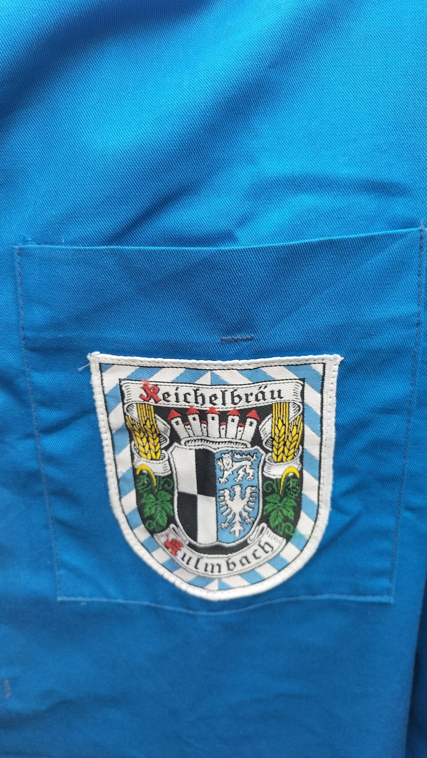 Hand painted French style worker overall. Lovely blue colour. "Shop floor worker" hand painted on the back of overalls. Front has a badge on it with Reichelbrau logo. Medium to large size. One off original.