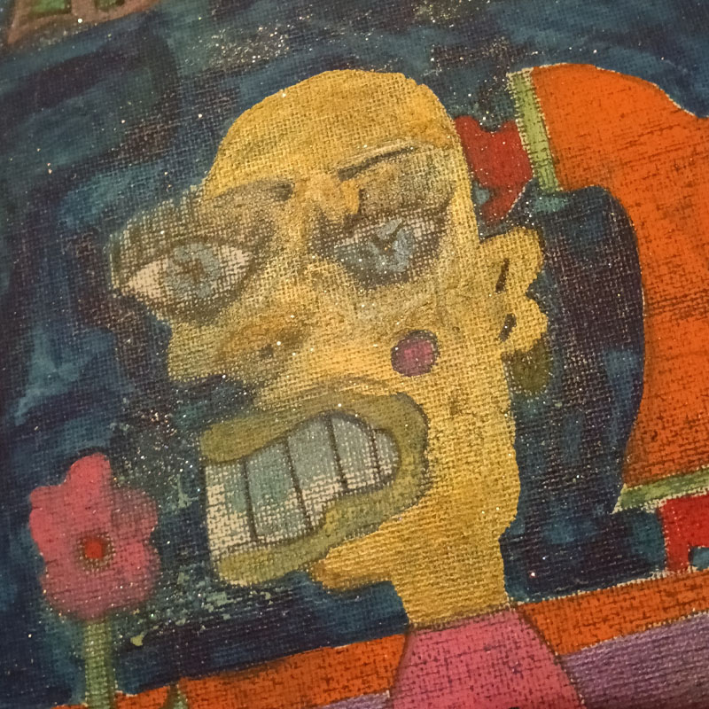 10"x12"canvas called the Orange Man. Large figure on the left holding a flower. Behind the figure is a sideboard and a smaller figure in some kind of yoga pose with one hand and one foot on the sideboard and the other foot and hand raised. There is a light at the top of the image. The smaller figure wears an orange jumpsuit. Blue background.