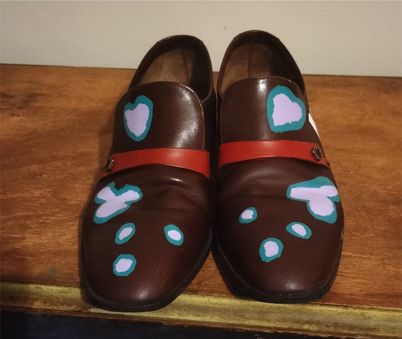 Handpainted size 7 brown leather shoes. Red stripe on the front and kind of liver shape painted on the front. Light pink with a pale blue surround. This is the shoes photographed from the front.