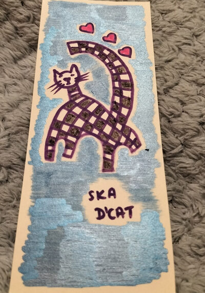 Ska d'cat little black and white cat, signature black and white squares associated with ska/two tone music. Little bookmark, blue background.