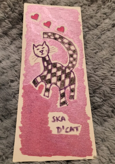 Ska d'cat bookmark. Pink background. Red hearts on the art work.