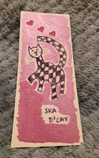Ska d'cat bookmark. Pink background. Red hearts on the art work.