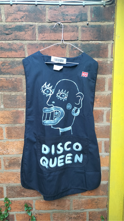 Disco Queen hand painted tabard. Dinner Lady disco style. Art work on the back reads Maam. On the front is a head (abstract style) and the words Disco Queen. Size XXL probably 12 to 14 UK size. £60 in the UK including postage. Navy blue.