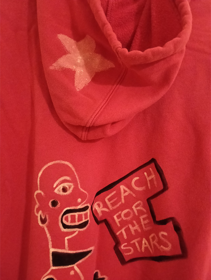 Gap hoodie size 16. Pink. Hand painted on the front. Woman figure around the A of the word Gap. Shows gap at top of legs which is referencing a woman's weight and space between her thighs. Sideboard to the left of the legs and shoes. Knee length socks. Dog to the right of the legs. Plant with leaves and flower on top of the sideboard. Vintage hoodie. Painted front and back. Back of hoodie has a star ont he hood and a figure on the back of the hoodie which is abstract, bald headed and the words Reach for the Stars appear in a box outline.Gap hoodie size 16. Pink. Hand painted on the front. Woman figure around the A of the word Gap. Shows gap at top of legs which is referencing a woman's weight and space between her thighs. Sideboard to the left of the legs and shoes. Knee length socks. Dog to the right of the legs. Plant with leaves and flower on top of the sideboard. Vintage hoodie. Painted front and back. Back of hoodie has a star ont he hood and a figure on the back of the hoodie which is abstract, bald headed and the words Reach for the Stars appear in a black line surround.