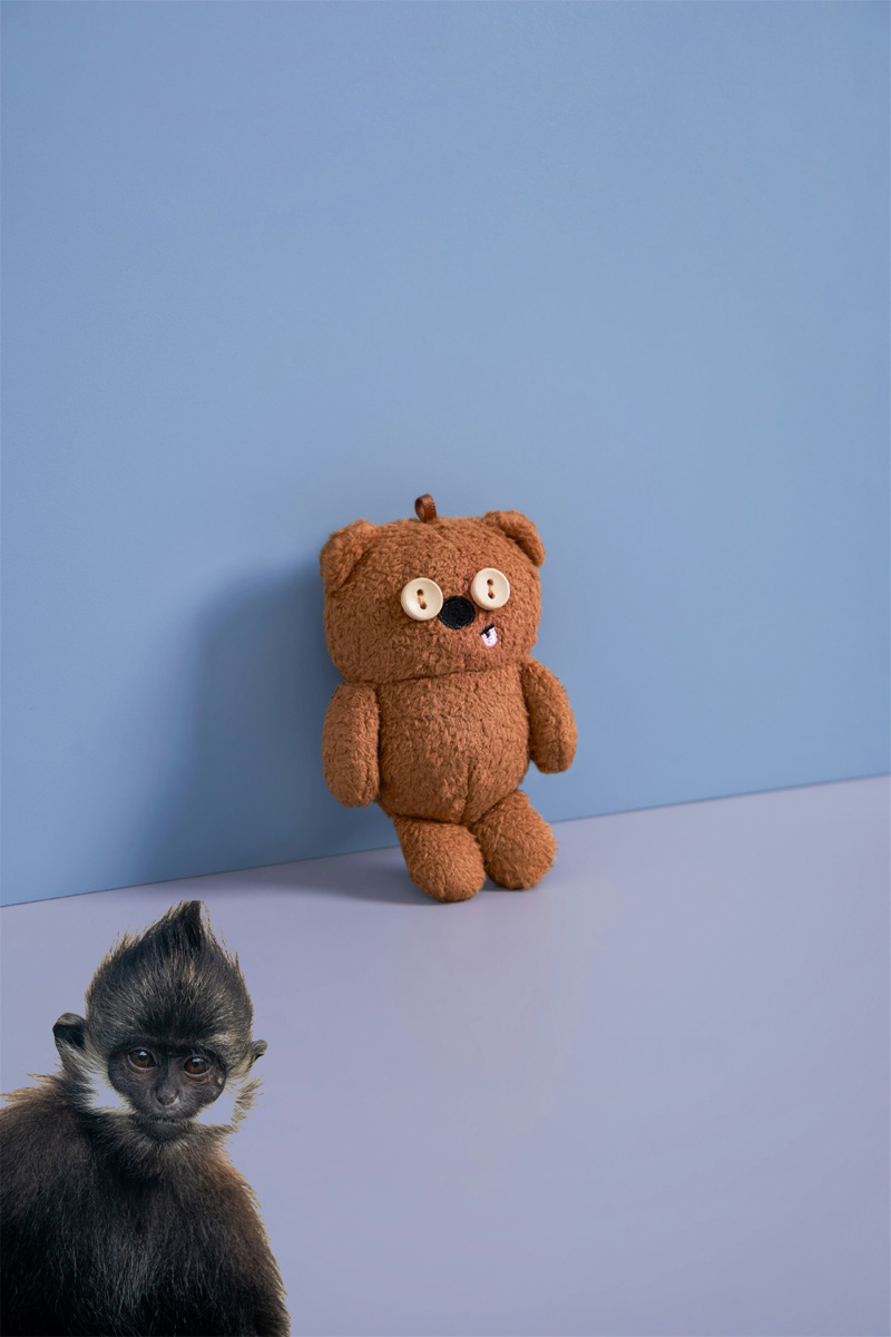 Teddy bear with buttons for eyes against a wall. Blue background. Slightly darker blue wall than the floor. Botton left of image is a monkey. This is about people having unconscious bias in the workplace and how businesses should consider keeping records for expired warnings, grievances etc.