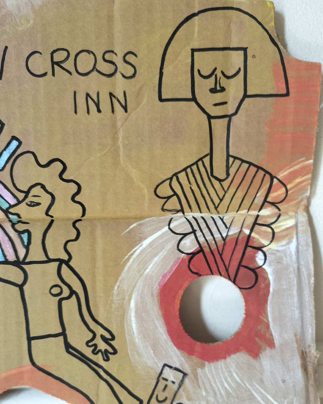 Art work on cardboard. One off. About A3 in size. Square in shape with two round holes (one on each side) and another kidney shaped hole in the middle of the card. The top left and right side of the card are like they have had a semi circle removed. Background: white and orange paint in parts as well as red paint. Two women holding hands, one reaching out to the other. One looks like she is sat on a tall object with a kind of mosaic surface. A bit like a tower. A kind of Pharoah-like figure at the top right of the art work. Blue and pink objects forming some kind of arch and then some oblong shapes above. Colours are alternated throughout. A little card shape with a smiling face near the one foot of each of the women. The art work is about a live music venue in South East London, the New Cross Inn.