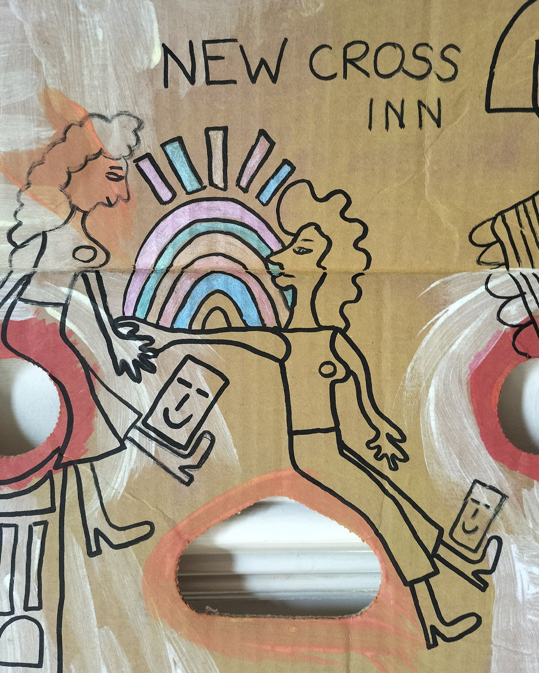 Art work on cardboard. One off. About A3 in size. Square in shape with two round holes (one on each side) and another kidney shaped hole in the middle of the card. The top left and right side of the card are like they have had a semi circle removed. Background: white and orange paint in parts as well as red paint. Two women holding hands, one reaching out to the other. One looks like she is sat on a tall object with a kind of mosaic surface. A bit like a tower. A kind of Pharoah-like figure at the top right of the art work. Blue and pink objects forming some kind of arch and then some oblong shapes above. Colours are alternated throughout. A little card shape with a smiling face near the one foot of each of the women. The art work is about a live music venue in South East London, the New Cross Inn.