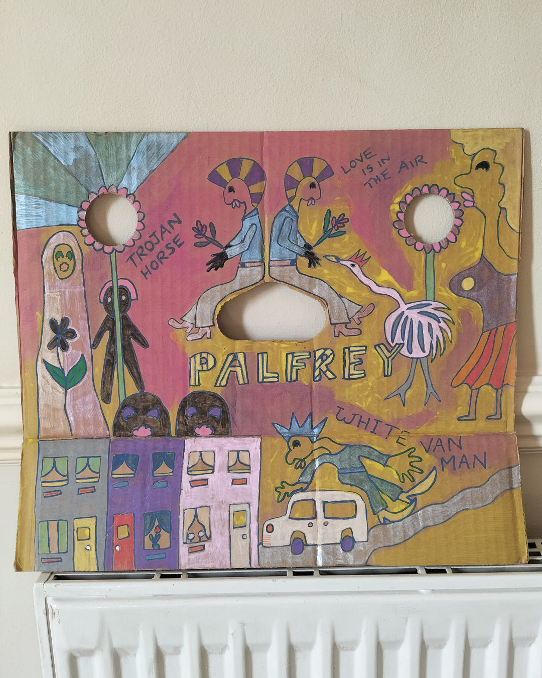 Art work on cardboard. One off. About A3 in size. Square in shape. Two round holes (one on each side) and another kidney shaped hole in the middle of the card. Background: pink and yellow in different areas. Row of houses white van and a man leaning over the van. Little path and the words White Van Man. Muslim woman on left of work. Stalk leading to hole in the cardboard and petals around the hole on both sides. Two figures sat back to back around the kidney shaped hole. The words Trojan Horse on the left of the work and Love is in the Air on the right of the work. The word Palfrey in big lettering in the middle. A bird looking up at one of the figures and a woman at the right of the image. Palfrey is an area near Walsall, West Midlands UK.