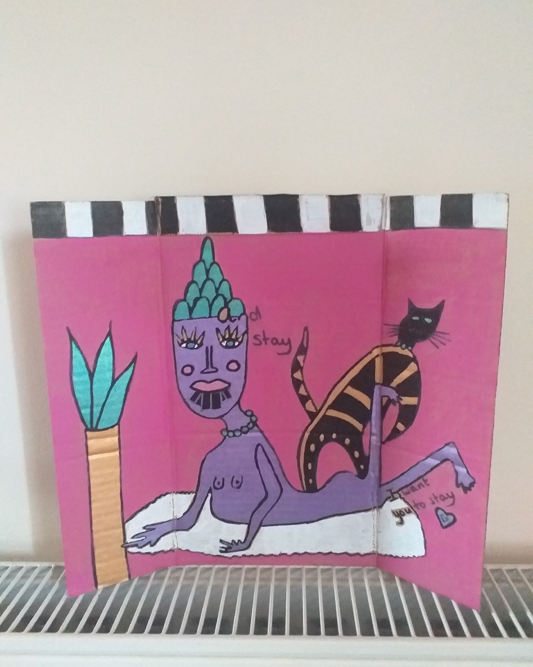 One for the lovers of Cilla Black piece uses some of the words of her song. Step inside love - and stay, I want you to stay cardboard art. About A4 landscape in size folded into three panels. When closed the front of the piece is like the front of a house. When opened it is a image of a purple woman on a rug with a cat and a plant. Front reads Step inside love. Inside reads and stay and lower down the image reads I want you to stay. The back of the image when opened out has painted parts on the left and right of the card and the centre piece is plain cardboard with a sticker on it. Step inside love on the front of the piece. Inside reads … and stay … I want you to stay.