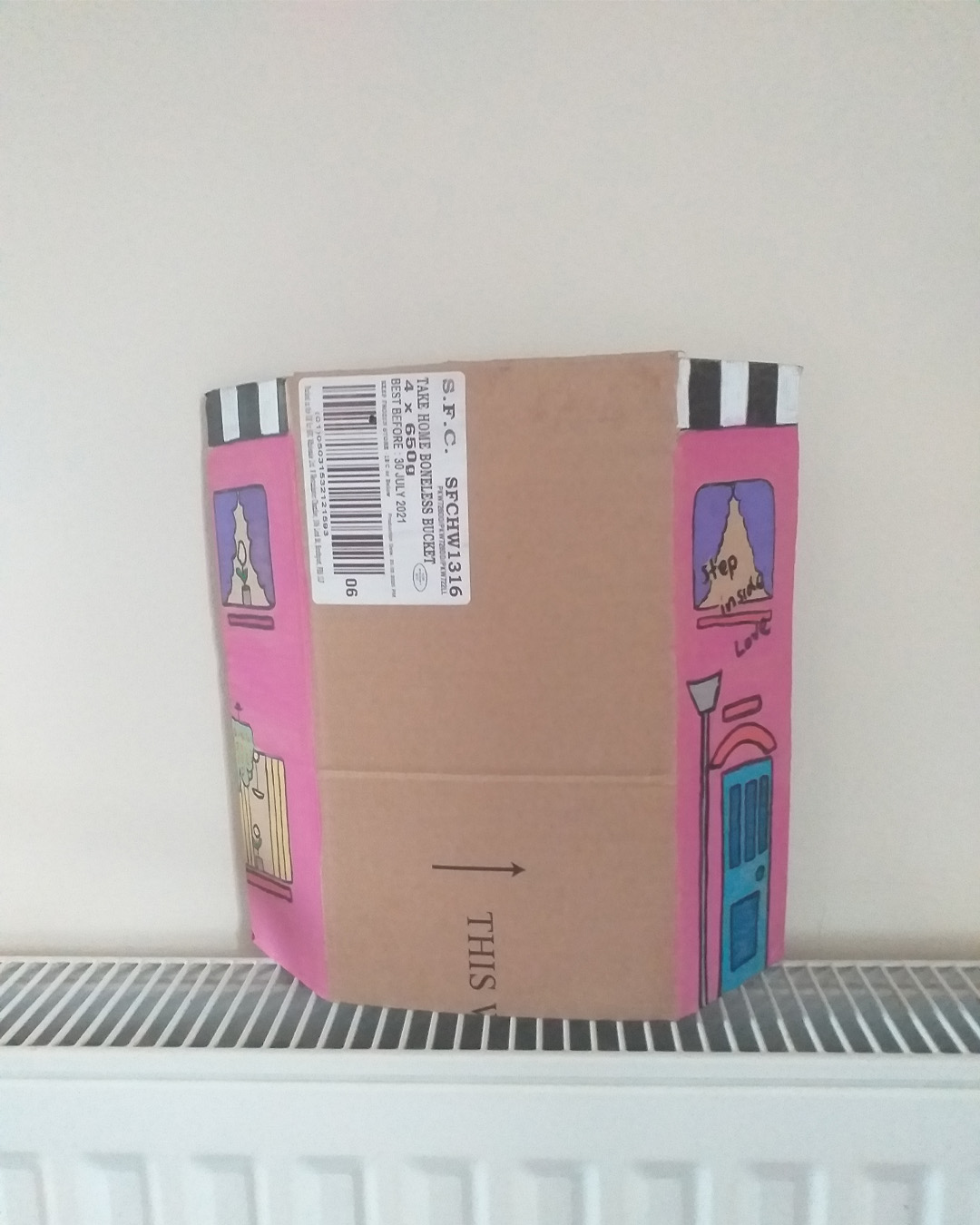 One for the lovers of Cilla Black piece uses some of the words of her song. Step inside love - and stay, I want you to stay cardboard art. About A4 landscape in size folded into three panels. When closed the front of the piece is like the front of a house. When opened it is a image of a purple woman on a rug with a cat and a plant. Front reads Step inside love. Inside reads and stay and lower down the image reads I want you to stay. The back of the image when opened out has painted parts on the left and right of the card and the centre piece is plain cardboard with a sticker on it. Step inside love on the front of the piece. Inside reads … and stay … I want you to stay.