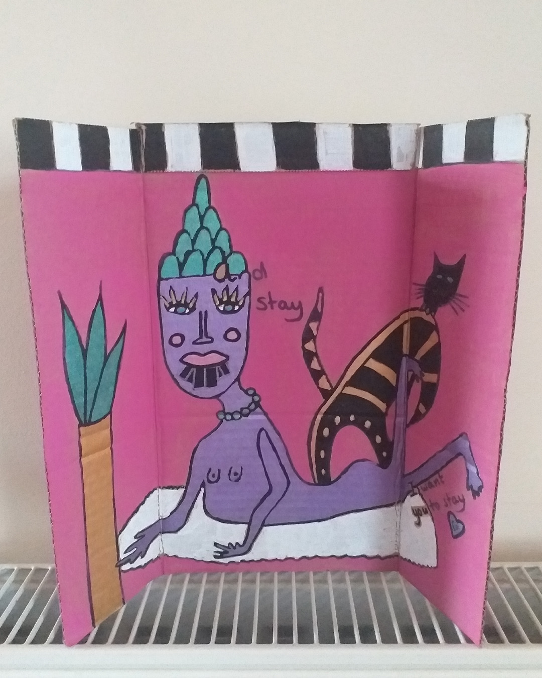 One for the lovers of Cilla Black piece uses some of the words of her song. Step inside love - and stay, I want you to stay cardboard art. About A4 landscape in size folded into three panels. When closed the front of the piece is like the front of a house. When opened it is a image of a purple woman on a rug with a cat and a plant. Front reads Step inside love. Inside reads and stay and lower down the image reads I want you to stay. The back of the image when opened out has painted parts on the left and right of the card and the centre piece is plain cardboard with a sticker on it. Step inside love on the front of the piece. Inside reads … and stay … I want you to stay.