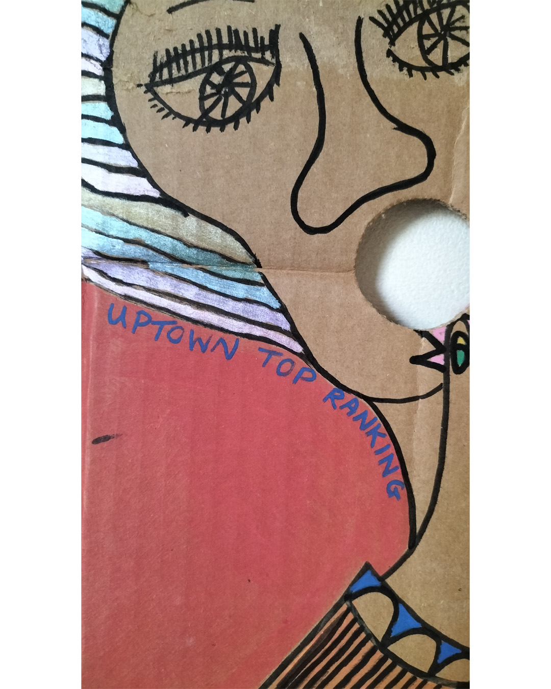 Close up of Uptown Top Ranking words around woman's hair and under face. The Locarno cardboard art about A3 in size. The Locarno was a nightclub in Birmingham and there were Locarno nightclubs across England. This is a scene with a woman's face in top left of cardboard where a hole is her mouth and the words Uptown Top Ranking run under her hairline and around her chin and neck. The hand of the woman is coming up from the bottom left of the cardboard and the fingers are extended and look like chickens with spikey hair and a beak around each finger and the nail looks like an eyeball with eyelid (not detailed). There is the words The Locarno on the piece and a man and woman standing talking at a tall table. There is another woman under the hand where you only see part of her face. To the right of the image is a doorway and it looks like inside a room with slabs for stairway leading there. This is only small on the right side of the cardboard. Background is pink for the bottom two thirds of the cardboard and a kind of orange for the top third of the card.