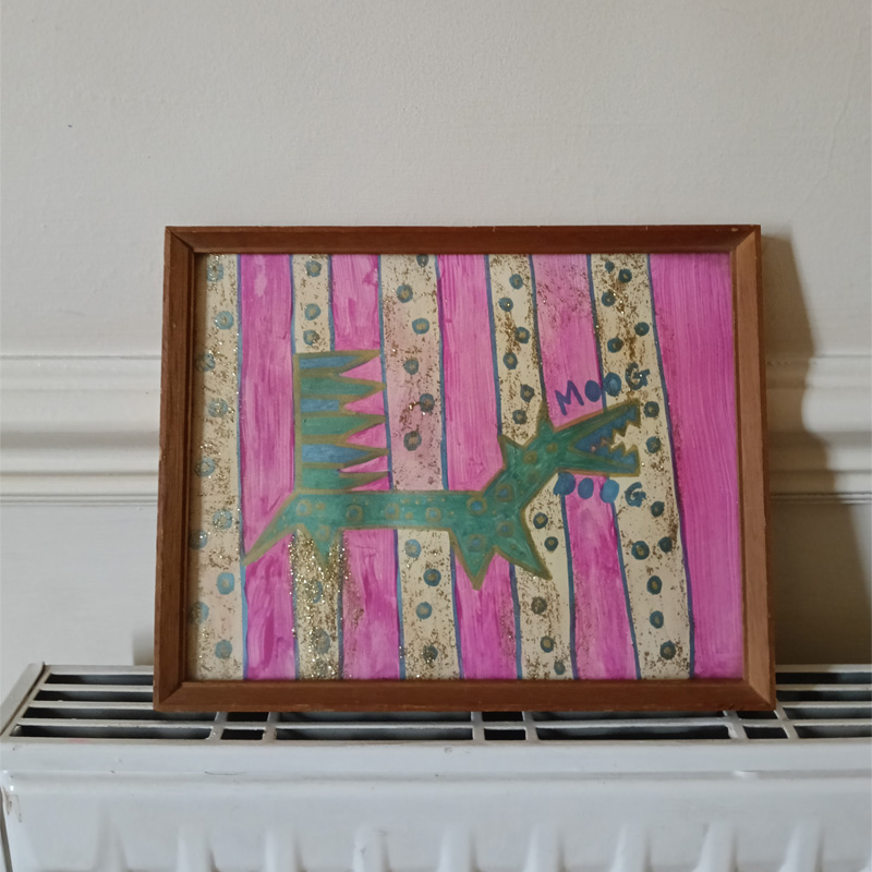 Moog Doog original art work framed. Brown used frame. Stripey background pink with clear stripes with dots of paint and glitter on the piece. The Moog Doog is a design based on the Moog synthesizer. A keyboard for a tail, straight on the left and zig zag on the right. The body of the dog has circles and dots on it representing the dials on the synthesizer. The word Moog is above the mouth and the word Doog below the mouth.
