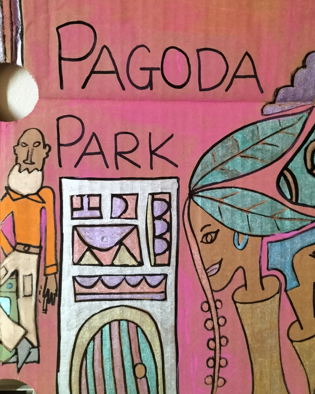 Night club scene on A3 cardboard. Man at cash counter and couple of heads coming out of what could be tree trunks. Two holes in the cardboard in the top third of the cardboard. One hone on the right is used as an empty face of a woman. Large figure at the top right of the cardboard. Head and shoulders and heart shape on the top of the person. Image that could be a fancy door with glass panels. Bit of the cardboard towards the top left has its top surface torn off. With the two heads that are coming out of tree trunks, one has leaves as hair. The words Pagoda Park on the cardboard.