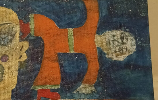 Cut out of Orange Man canvas. Small figure in yoga pose and part of a large head to the left.