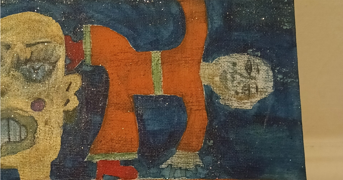 Cut out of Orange Man canvas. Small figure in yoga pose and part of a large head to the left.