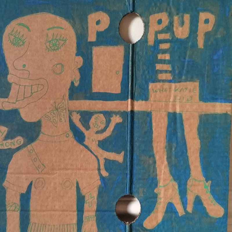 What Katie did cardboard art. A3. Large figure on left lifting a weight. Bald head. Quirky drawing. Small figure on shoulder waving. Could be alter ego, could be a memory or that little niggling thought. Image has a horizontal strip across it, not high. On the right of image lower half of woman's body. Reads "What Katie did" on the area for pants and below legs with ankle high bootgs/shoes. Reads Pop Up above and a hole in the cardboard where the O is. There a door above the line too. Blue backgound and figure and drawing do not have any colour inside, just outlines. One-off.